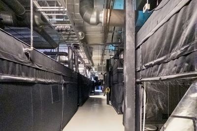 Circulation between cultivation enclosures; process services run overhead at height